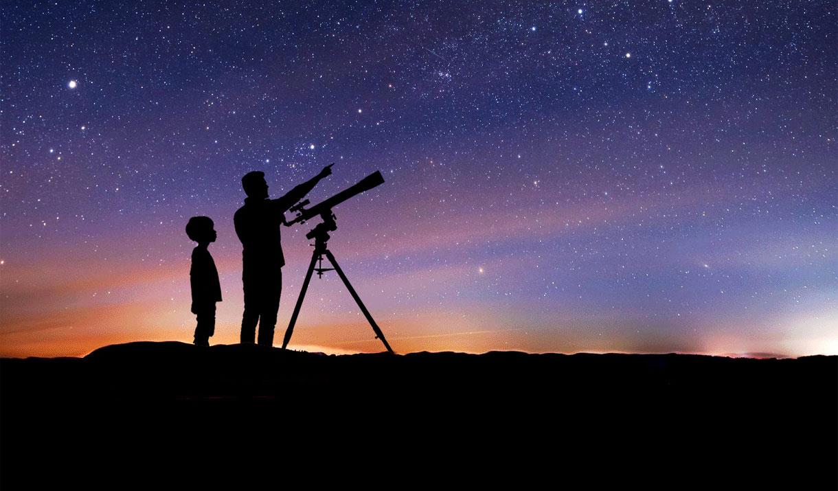 Silhouette of a Family Stargazing with a Telescope