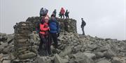 Climbers at the Peak of Scafell Pike with Rock n Ridge in the Lake District, Cumbria