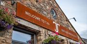 Exterior Signage and Flowers at TJ's Bar and Restaurant at Park Foot Holiday Park in Pooley Bridge, Lake District
