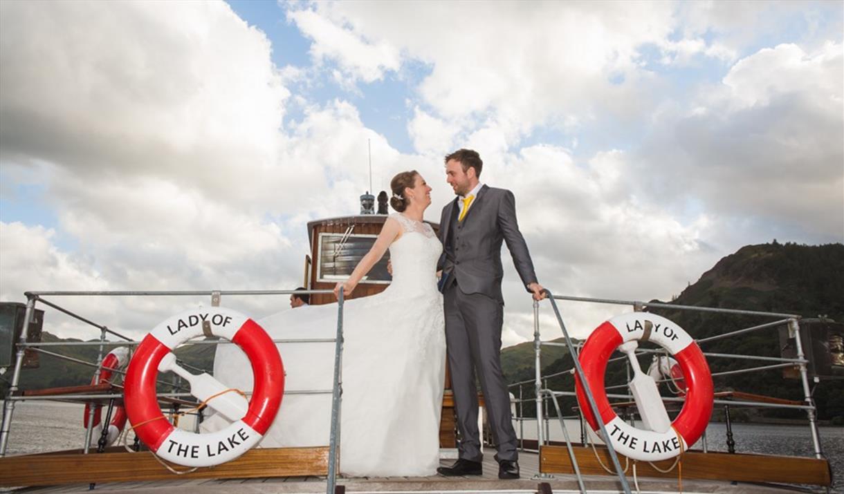 Just married couple standing on Lady of the Lake heritage vessel, Ullswater 'Steamers' Cumbria.