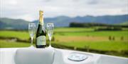 Prosecco and Glasses on the Side of a Hot Tub at Wellington Farm Glamping Pods in Cockermouth, Cumbria