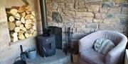 Wood Burner and Lounge Chair at Midtown Farm Bed and Breakfast in Easton, Cumbria
