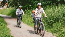 A family with a small child cycling along the Llangollen canal