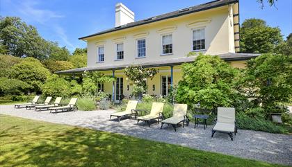 Plas Bodegroes outside shot of the house with sun loungers outside.