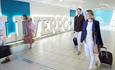Two passengers walking past the Liverpool sign on their way to the departure lounge