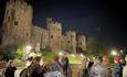 A ghost tour outside Conwy Castle at night