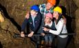 A family standing together looking over a rail in the underground.