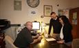 This image shows a man and a woman being checked in by a man at the front desk