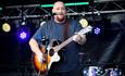 A solo guitarist on stage singing live at one of our previous events.