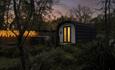 Offa glamping pod at night with hot tub and fairy lights