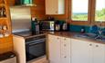 Picture of white kitchen cupboards with oven and sink.