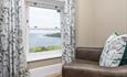 Chair looking out of bedroom window with sea views