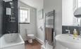 Gors-lwyd Cottage bathroom with shower over the bath, toilet, sink and towel radiator