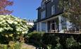 Wenallt Guest House front entrance from the garden on a sunny day.