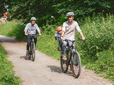 A family with a small child cycling along the Llangollen canal