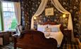 Comfortable Luxury Room with Large King Bed, drapes above the bed with wonderful light coming through the bay Window