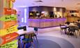 quirky bar with neon lighting and brightly coloured signposting
