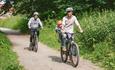 A family with a small child cycling along the Llangollen canal