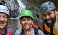 A father and son with their guide in the Afon Ddu Gorge a waterwall behind them