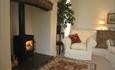 cosy sitting room with lit woodstove in the Front Wing at Pen y Graig