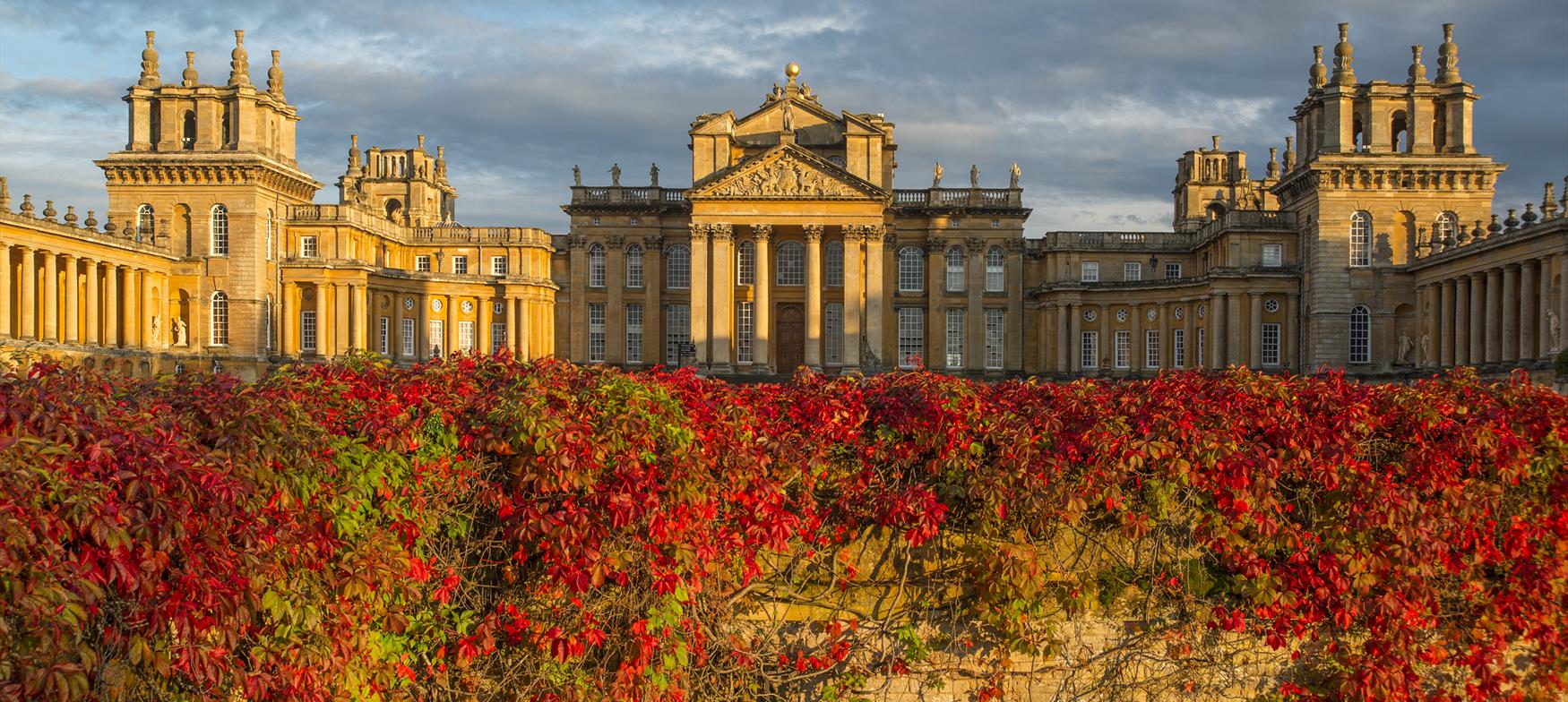 Wall covered in red and orange leaves in front of Blenheim Palace