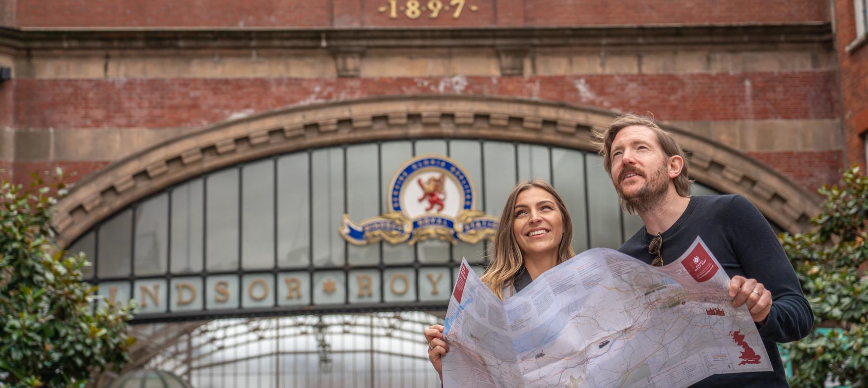 Couple looking at Great West Way Map outside Windsor Royal Station