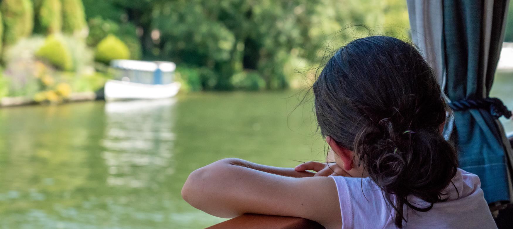 Girl looking out at river from boat