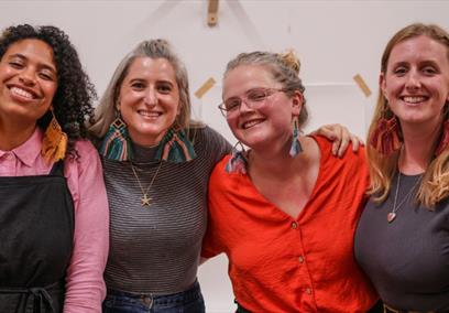 Four women wearing macrame earrings