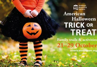 A little girl holding a Jack O'Lantern standing in a garden full of fallen leaves