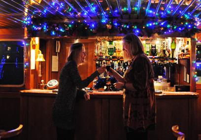 Two ladies at the bar with mulled wine and Christmas lights