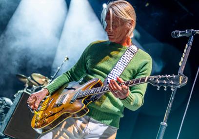 Paul Weller playing guitar on stage