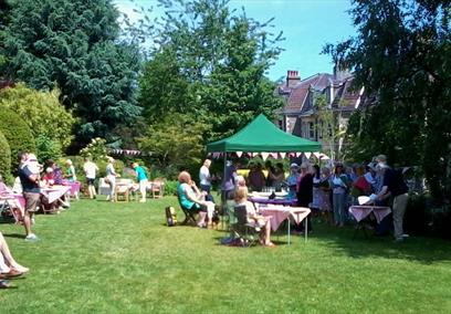 A garden with people sat on lawn furniture