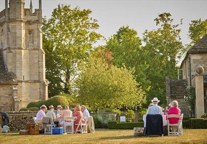 People sat outside in sunshine in countryside