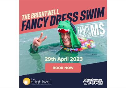 A man wearing a dinosaur onesie swimming