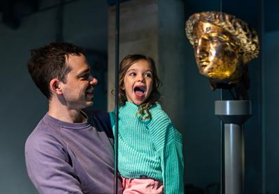 child and parent looking at statue of Minerva at The Roman Baths
