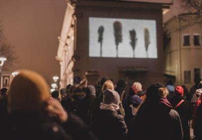 A large group of people watching a film on the side of the building