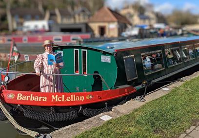 Lady reading a book on bow of a canal boat