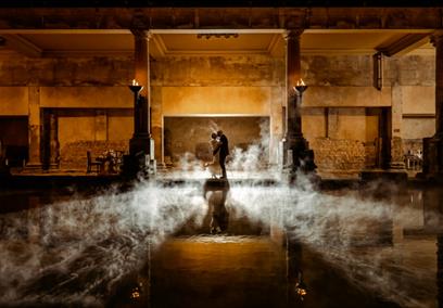 A newly married bride and groom alongside the Great Bath at The Roman Baths in Bath