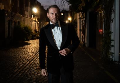 Matt Goss walking down a dimly lit street
