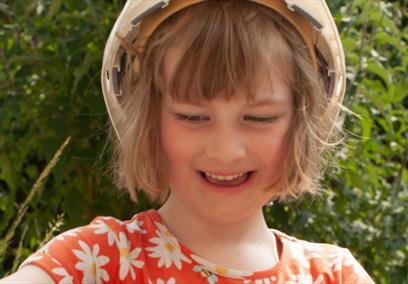 Young girl wearing a hard hat using clay