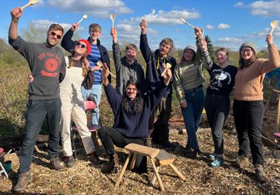 A group of people holding up wooden spoons