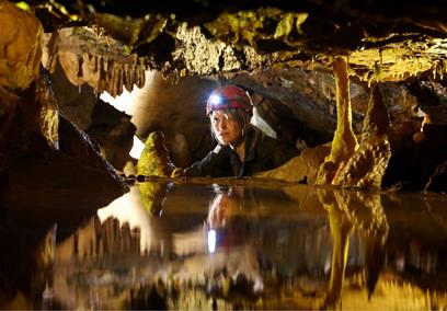 Girl in cave looking at stalactites