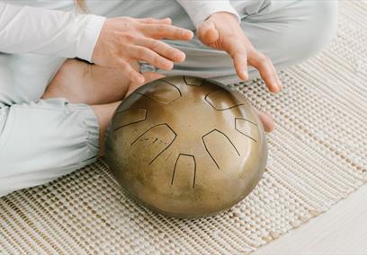 A pair of hands hovering above a gold bowl
