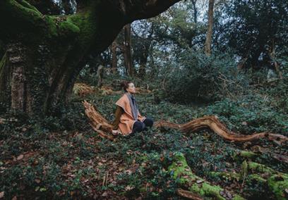 Women sat on a tree in the forest