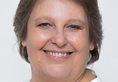 A woman smiling against a white background