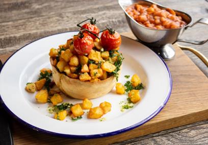 Brunch pie topped with potatoes and vine tomatos