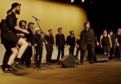 The Spooky Men's Chorale performing on stage.
