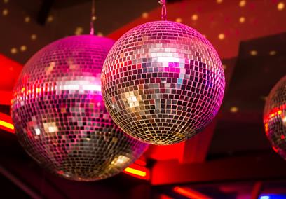 A mirrorball with pink lights shining on it