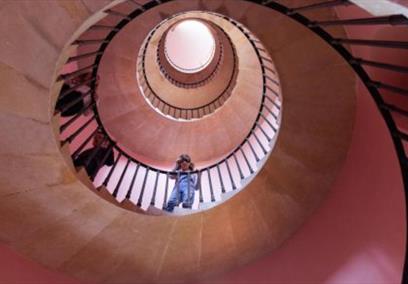 Photo of girl looking down at the camera from a spiral staircase