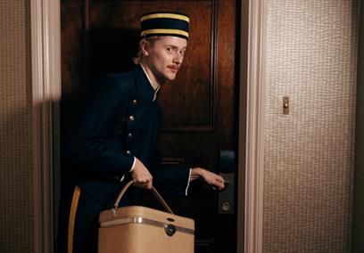 Bell boy opening a door in a hotel